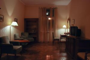 Habitación con sala de estar con TV y sillas. en Central Apartments Lviv en Leópolis