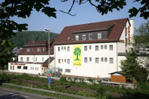 a white building with a tree painted on it at Hotel-Linde-Restaurant Monika Bosch und Martin Bosch GbR in Heidenheim an der Brenz