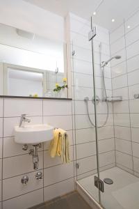 uma casa de banho com um lavatório e um chuveiro em Hotel-Linde-Restaurant Monika Bosch und Martin Bosch GbR em Heidenheim an der Brenz