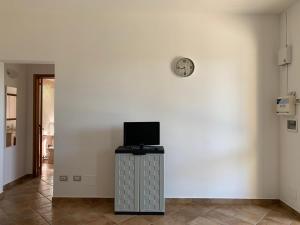 a room with a white wall and a clock on the wall at Tenuta Punta della Suina in Gallipoli