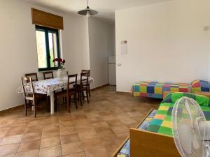 a living room with a table and chairs and a bed at Tenuta Punta della Suina in Gallipoli