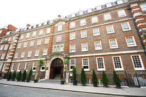 a large red brick building with trees in front of it at Gem Fitzrovia Hotel in London