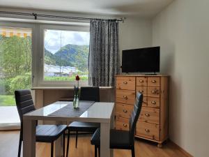 uma sala de jantar com uma mesa, uma televisão e uma janela em Ferienwohnung BerGlück em Inzell