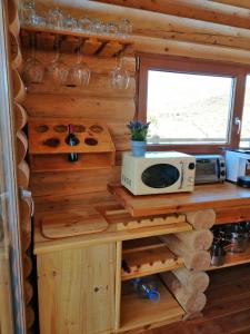 eine Küche in einem Blockhaus mit einer Mikrowelle auf der Theke in der Unterkunft Ca'Lila in Pulpí