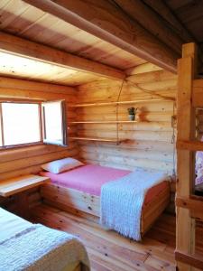 una camera da letto in una baita di tronchi con 2 letti di Ca'Lila a Pulpí