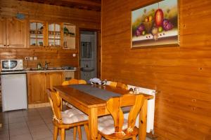 a wooden kitchen with a wooden table and chairs at Családbarát Faház in Kehidakustány