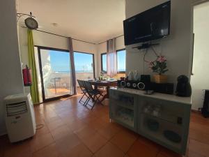 a living room with a television and a dining room table at Algarve Vacations Flat in Albufeira