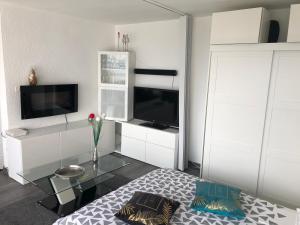 ein Wohnzimmer mit einem Glastisch und einem TV in der Unterkunft Petit moment de Bonheur in Turckheim
