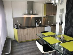 a kitchen with a glass table and some chairs at Petit moment de Bonheur in Turckheim