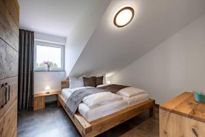 a bedroom with a wooden bed with a window at Grünten-Chalet in Oy-Mittelberg