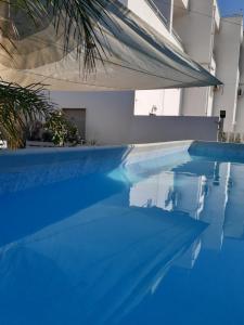 a swimming pool with blue water in a building at Residence San Vito in Mazara del Vallo