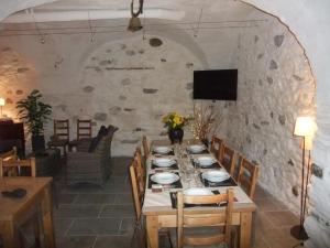 a dining room with a table with chairs and a tv at Le Domaine du Grand Cellier Chambres d'hôtes en Savoie in Tournon