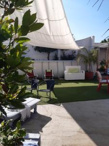 a patio with chairs and a lawn with a white fence at Residence San Vito in Mazara del Vallo