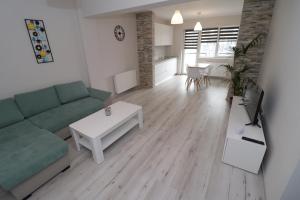 sala de estar con sofá verde y mesa en Apartament 2 camere Anto en Sibiu