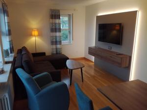 a living room with a couch and a flat screen tv at Lindner's Apartment in Bellheim