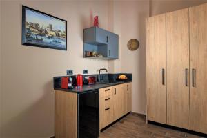 a kitchen with a sink and wooden cabinets at Grand Master Suite in Rhodes Town