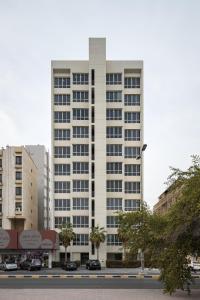 a tall white building with cars parked in front of it at Code Housing - Salmiya-Family only in Kuwait