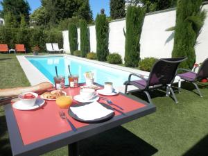 a table with food and drinks next to a swimming pool at Bordeaux Cosy B&B in Bordeaux