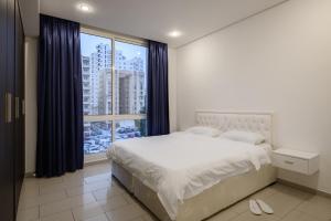 a bedroom with a bed and a large window at Code Housing - Salmiya-Family only in Kuwait