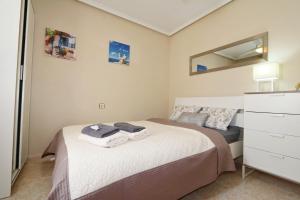 トレビエハにあるBungalow Torrevieja 4338の小さなベッドルーム(ベッド1台、ドレッサー付)