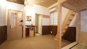 a room with a staircase and a kitchen at Poly Hostel 2 Namba in Osaka