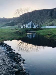 a body of water with a house in the background at Hamrafoss Holiday Home in Foss a Sidu