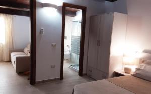 a bedroom with a mirror and a bed and a couch at AL PEZ exclusive rooms in Olbia