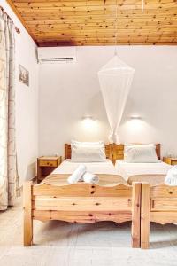een slaapkamer met een groot houten bed in een kamer bij Villa Danai in Agios Georgios Pagon