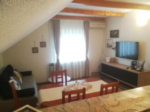 a living room with a table and chairs and a window at Guest House Bruna in Drežnik Grad