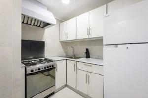 a white kitchen with a stove and a sink at salmiya - Amman -Family only in Kuwait +15 photos