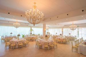 a banquet hall with tables and chairs and chandeliers at Finca El Campo in Algeciras +50 photos