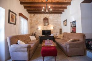 a living room with two couches and a coffee table at DROUSHIA CORNER HOUSE in Droushia