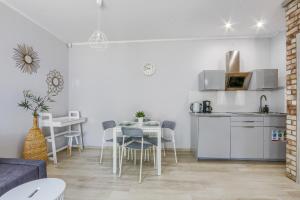 a kitchen and a living room with a table and chairs at Lion Apartments - Haffnera 19 in Sopot