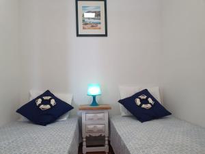 - 2 lits avec des oreillers bleus et une lampe sur une table de chevet dans l'établissement Spondylus Apartment, à Empuriabrava