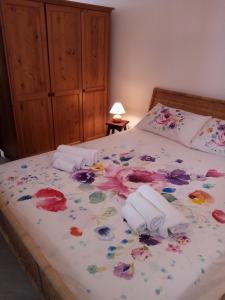Bett mit Blumenbettdecke und Blumen drauf in der Unterkunft Sweet Home by Giò in Mola di Bari