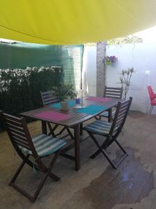 ビーゴにあるCasa La Floridaのピクニックテーブル(椅子付)、黄色と紫の傘