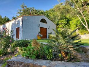 a small white building with a door in a garden at Chiosi Country Club in Corleone