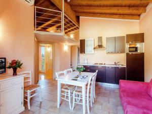 ポルペナッツェ・デル・ガルダにあるCozy Holiday Home in Lombardy with Swimming Poolのキッチン、リビングルーム(白いテーブル、椅子付)