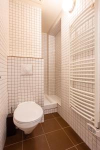 a white tiled bathroom with a toilet and a shower at Wonderful home in PARIS in Paris
