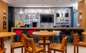 欧里尼奥斯ibis Ourinhos的餐厅内带木桌椅的酒吧