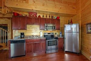 eine Küche mit Holzschränken und Küchengeräten aus Edelstahl in der Unterkunft Heavenly View in Sevierville