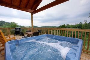 einen blauen Whirlpool auf einer Terrasse mit Grill in der Unterkunft Heavenly View in Sevierville