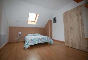 Schlafzimmer mit einem Bett und Holzboden in der Unterkunft VIVA LA VIDA in La Fère