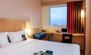 ein Hotelzimmer mit einem Bett und einem Schreibtisch mit einem Laptop in der Unterkunft ibis Ourinhos in Ourinhos + 119 Fotos