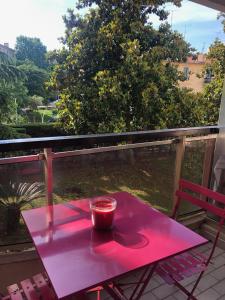 einen rosa Tisch auf einem Balkon mit einer Tasse drauf in der Unterkunft Cannes center in Cannes