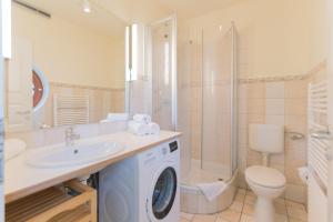 un bagno con lavatrice e WC di Ferienhaussiedlung Strandperlen Buchenhof 4d (Typ IV) a Wustrow Altre 14 foto