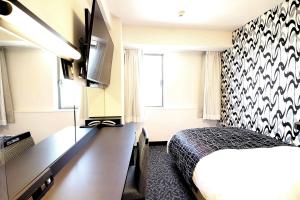 佐賀市にあるアパホテル 佐賀駅南口のベッドとデスクが備わるホテルルームです。