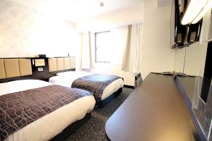 佐賀市にあるアパホテル 佐賀駅南口のベッド2台と大きな窓が備わるホテルルームです。