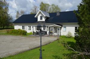 une maison blanche avec un toit noir dans l'établissement Högsnäsgården, à Överhörnäs