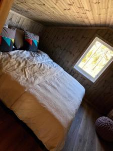 a bed in a small room with a window at Tuddal Hyttegrend HYTTA KÅNS in Hjartdal